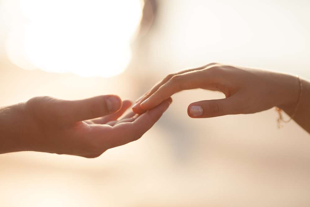 Two hands reaching for each other